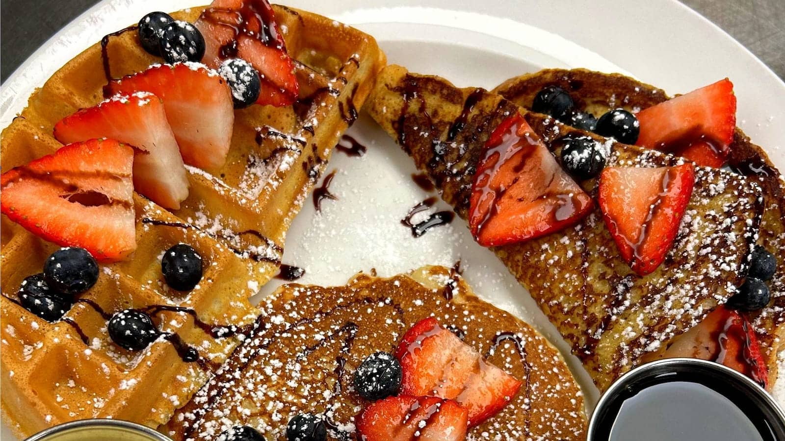 Waffles, French toast, and pancakes topped with fresh strawberries and blueberries at Bailey’s Breakfast & Lunch in Omaha